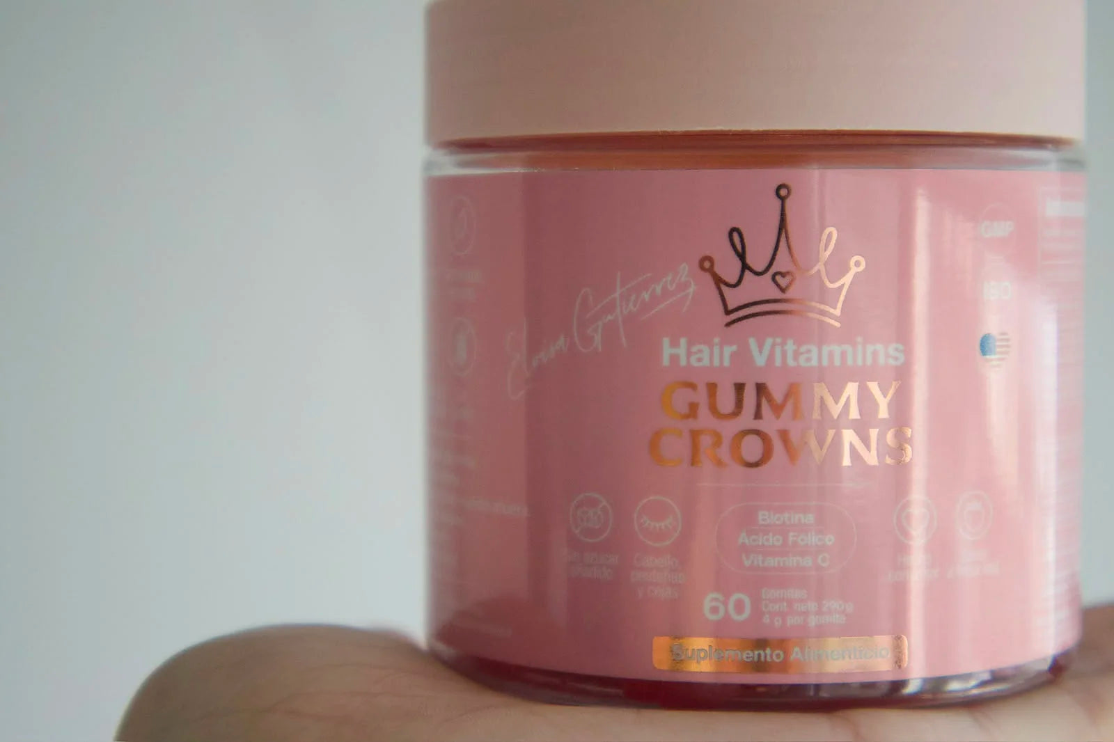 Bote de Gummy Crowns sostenido en una mano